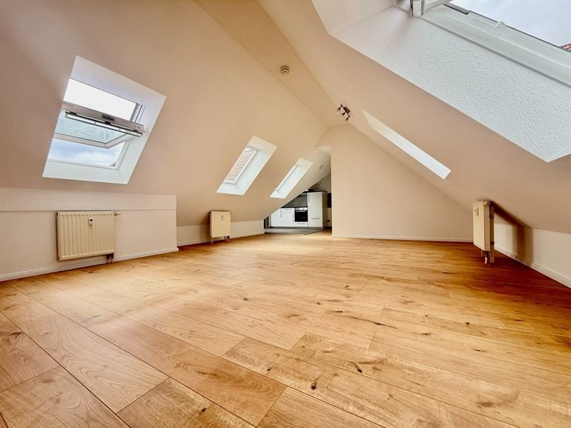 Heller Dachgeschossraum der vermittelten Wohnung in der Brunnenstraße in Leipzig-Liebertwolkwitz mit Dachfenstern und Parkettboden